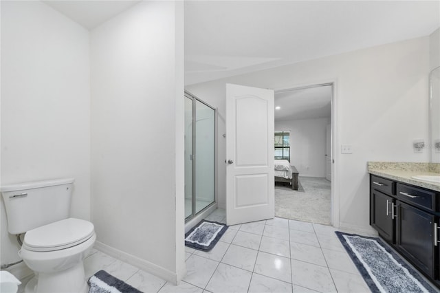 bathroom featuring toilet, vanity, and a shower with door