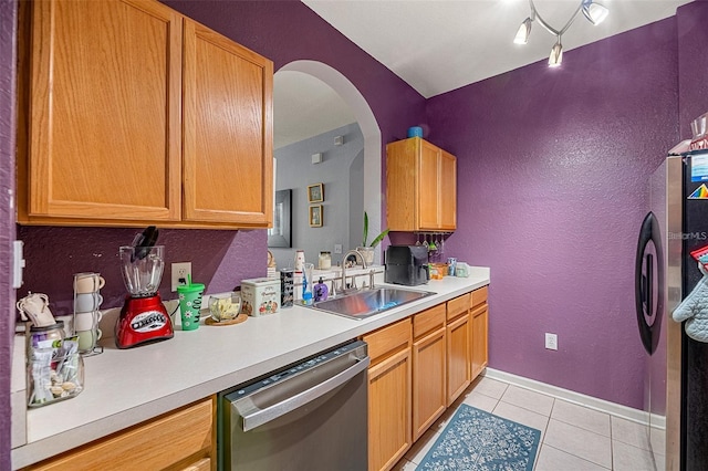 kitchen with light tile patterned flooring, stainless steel appliances, rail lighting, and sink