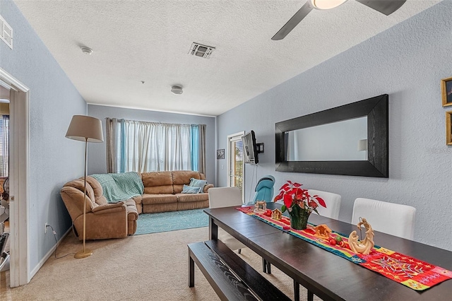 carpeted living room featuring ceiling fan and a textured ceiling