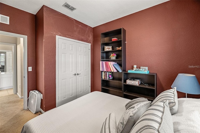 carpeted bedroom with a closet and a textured ceiling