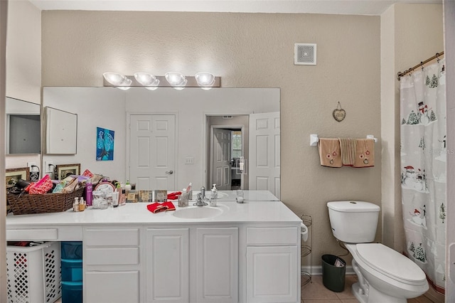 bathroom with toilet, vanity, tile patterned flooring, and walk in shower