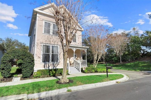 view of front facade with covered porch and a front lawn