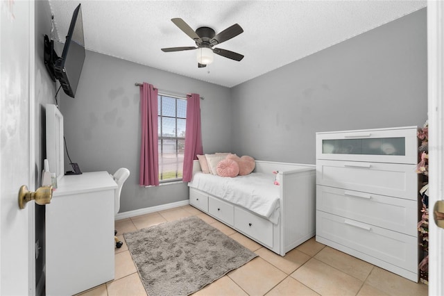 bedroom featuring a textured ceiling, ceiling fan, and light tile patterned floors