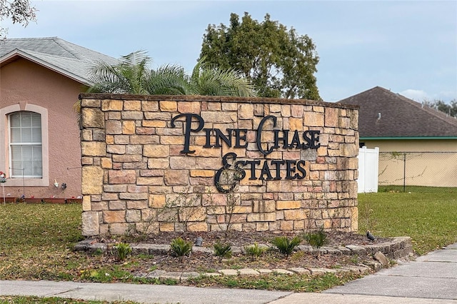 community / neighborhood sign featuring a lawn