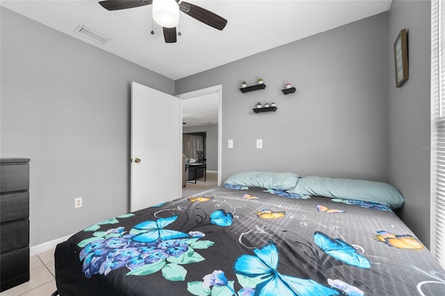 tiled bedroom featuring a textured ceiling and ceiling fan