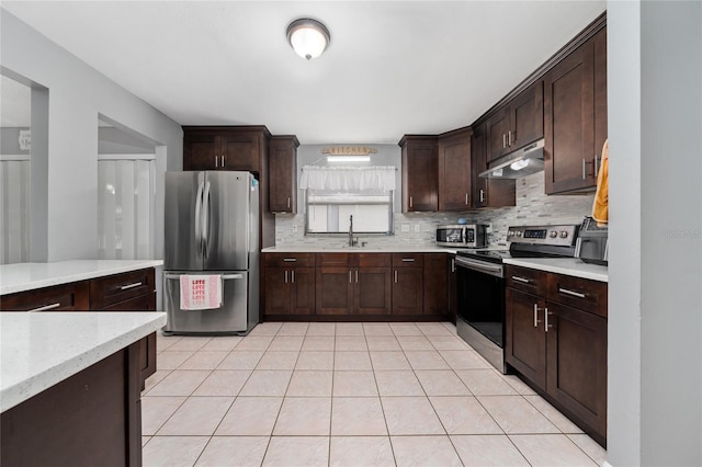 kitchen featuring dark brown cabinets, appliances with stainless steel finishes, backsplash, and light tile patterned floors