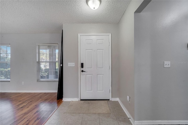 tiled entryway with a textured ceiling