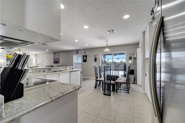 kitchen featuring stainless steel refrigerator, light stone counters, white dishwasher, pendant lighting, and white cabinets