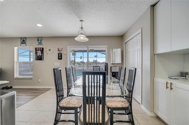 dining area featuring light tile patterned floors and a textured ceiling