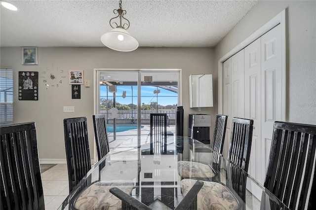 tiled dining space with a textured ceiling