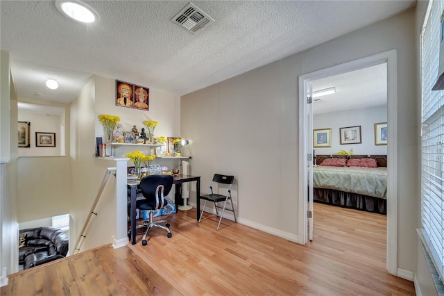 home office featuring a textured ceiling and light wood-type flooring