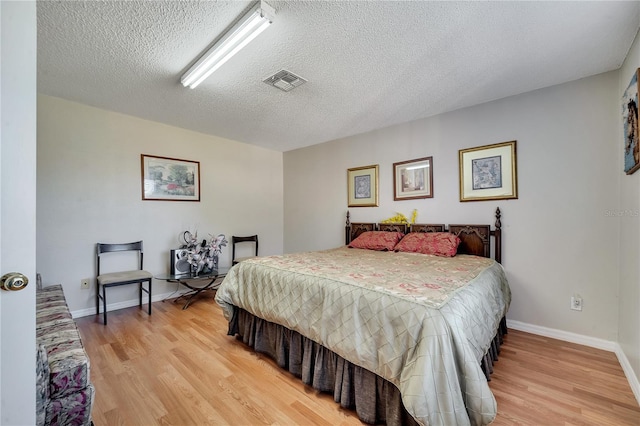 bedroom with wood-type flooring and a textured ceiling