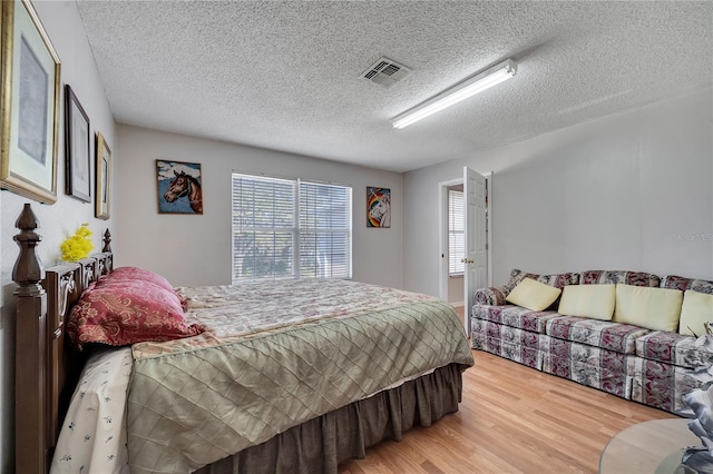 bedroom with hardwood / wood-style floors and a textured ceiling