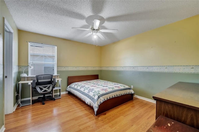 bedroom featuring hardwood / wood-style floors, a textured ceiling, and ceiling fan