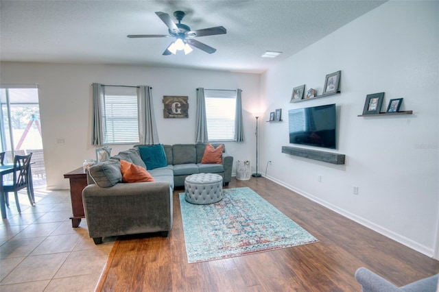 living room with ceiling fan, wood-type flooring, and a textured ceiling