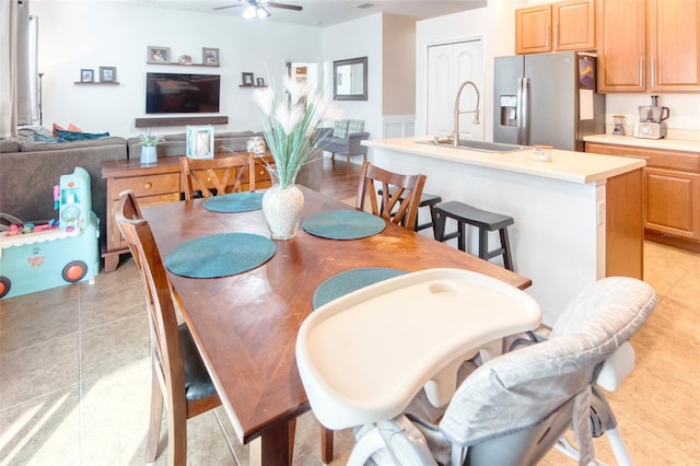 tiled dining area featuring ceiling fan and sink