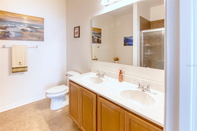 bathroom featuring tile patterned flooring, vanity, toilet, and a shower with door