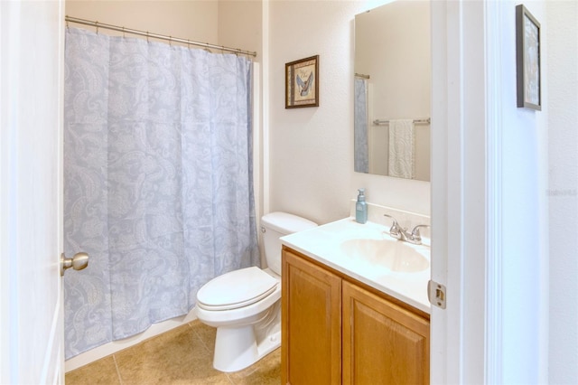 bathroom with toilet, vanity, and tile patterned floors