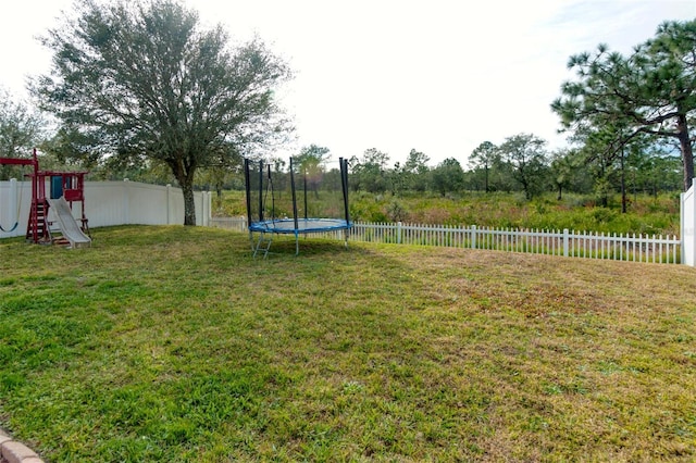 view of yard featuring a playground and a trampoline