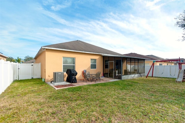 back of house featuring a lawn, central air condition unit, a sunroom, and a patio