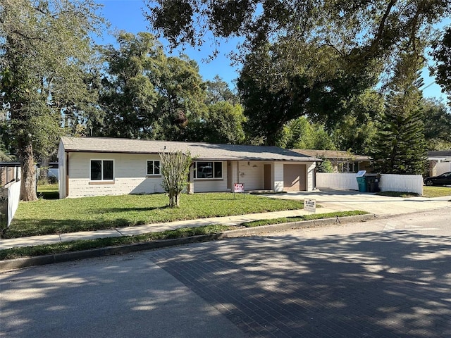 single story home with a garage and a front lawn