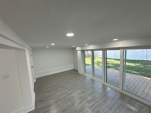 spare room with recessed lighting, a textured ceiling, baseboards, and wood tiled floor