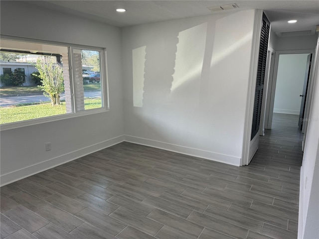 empty room featuring baseboards, wood tiled floor, visible vents, and recessed lighting