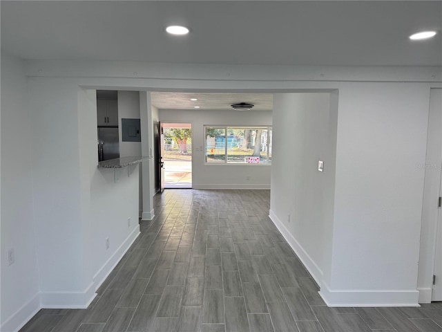 hall featuring wood tiled floor, baseboards, and recessed lighting