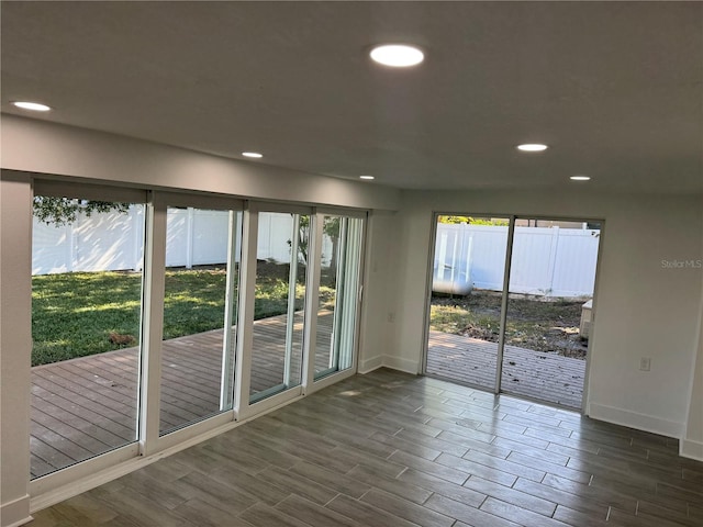 unfurnished room featuring recessed lighting, plenty of natural light, and wood tiled floor