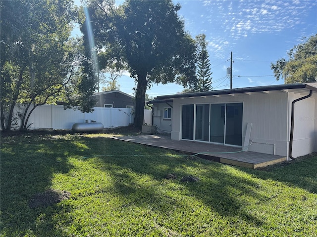 rear view of house featuring a patio area, a yard, and fence