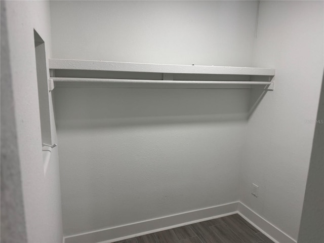 spacious closet with dark wood-style flooring