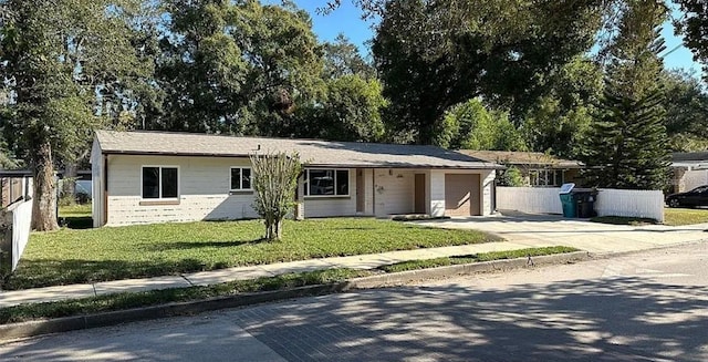 single story home with an attached garage, fence, a front lawn, and concrete driveway