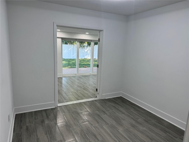 spare room with wood tiled floor and baseboards