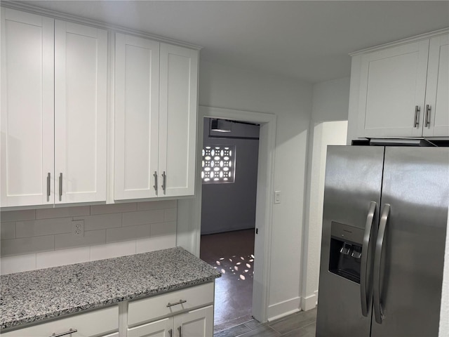 kitchen featuring backsplash, white cabinets, and stainless steel refrigerator with ice dispenser