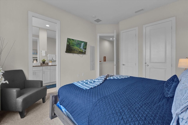 carpeted bedroom featuring ensuite bath