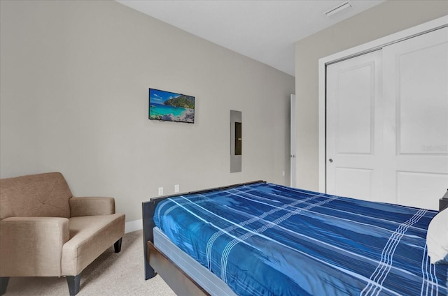 carpeted bedroom featuring electric panel and a closet