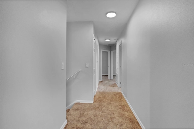 hallway featuring light colored carpet