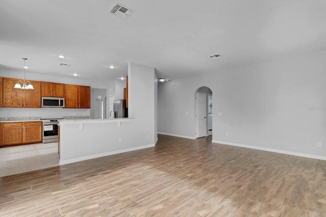 unfurnished living room featuring a chandelier