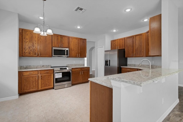 kitchen with a breakfast bar area, stainless steel appliances, hanging light fixtures, kitchen peninsula, and a notable chandelier