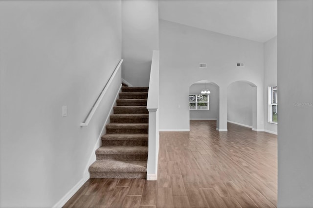 stairway featuring high vaulted ceiling