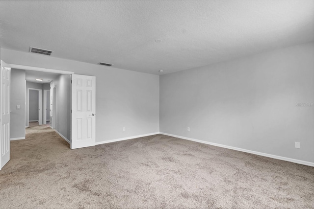 unfurnished room with a textured ceiling and carpet flooring