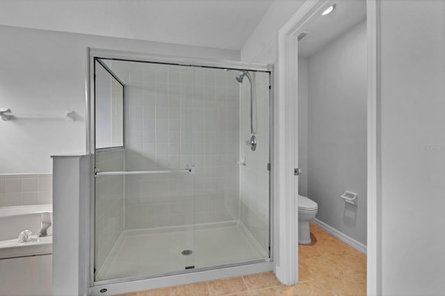 bathroom featuring toilet, an enclosed shower, and tile patterned flooring