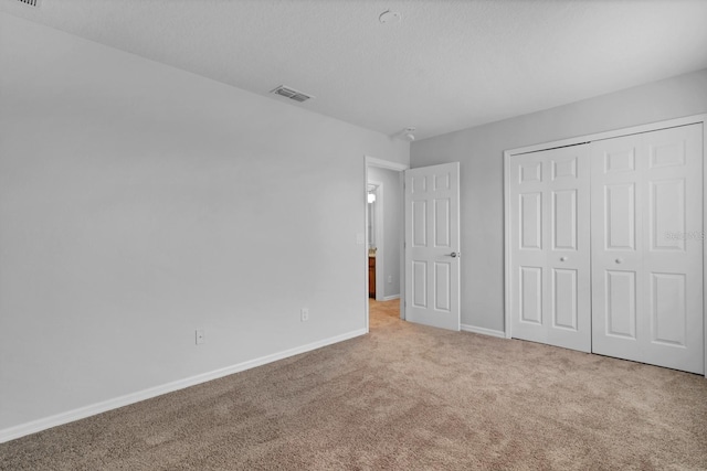 unfurnished bedroom featuring a closet and light carpet