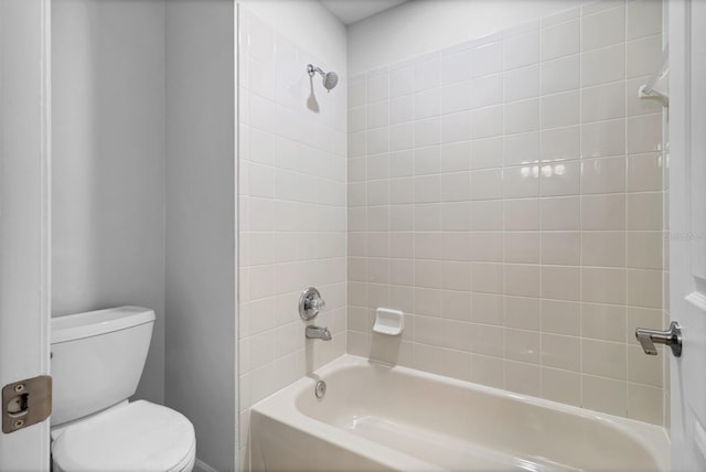 bathroom featuring tiled shower / bath combo and toilet