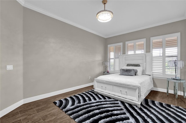 bedroom featuring baseboards, ornamental molding, and wood finished floors