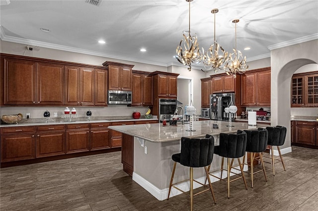 kitchen featuring stainless steel appliances, an island with sink, a kitchen breakfast bar, and dark wood-style floors