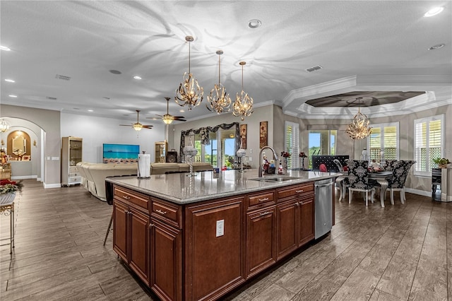 kitchen featuring arched walkways, visible vents, an inviting chandelier, open floor plan, and a sink