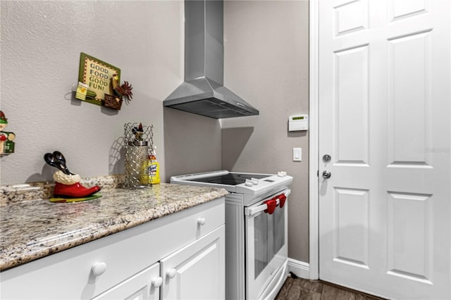 kitchen with white cabinetry, light stone countertops, dark wood-style floors, wall chimney exhaust hood, and white range with electric cooktop