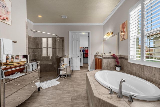 bathroom with ornamental molding, a stall shower, a garden tub, and vanity