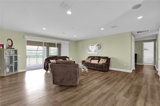 living room featuring baseboards, wood finished floors, visible vents, and recessed lighting